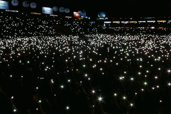 Público acende lanternas dos celulares e produz uma constelação na arena; veja ao vivo