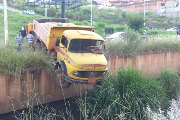 Caminhão basculante volta na avenida Paranaíba e fica pendurado no Córrego Monjolo