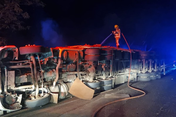 Carreta tomba na BR-365, carga pega fogo e motorista é levado ao hospital com pressão alta