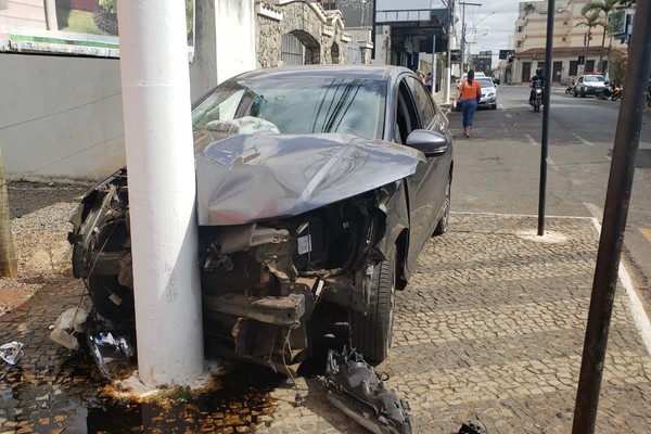 Motorista passa mal, bate em caminhão e moto e vai parar em poste no centro de Patos de Minas