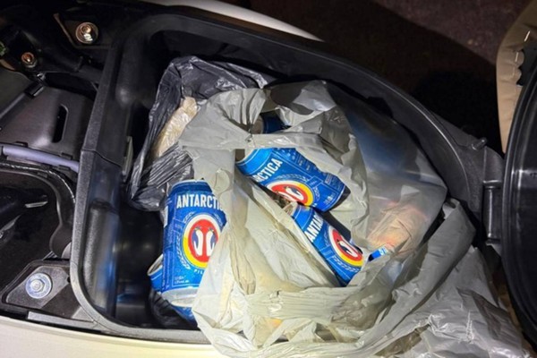 Condutora cai na Rua São Geraldo e acaba presa com baú da moto cheio de cervejas