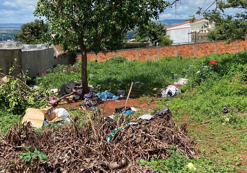 Mulher que vive em lote vago leva lixo para o local e deixa moradores preocupados, em Patos de Minas