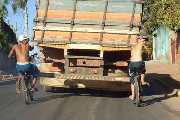 Ciclistas ignoram as leis de trânsito e arriscam a vida pegando rabeira