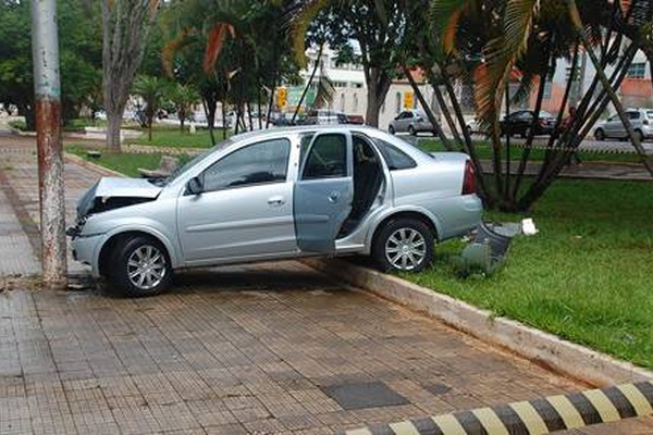 Carro vai parar em poste no meio de praça em acidente no centro de Patos de Minas