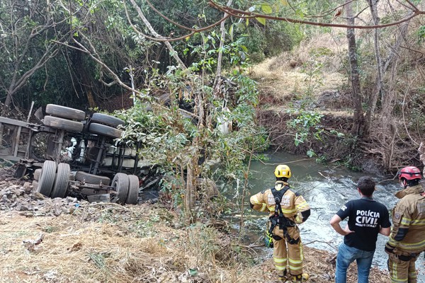 Bitrem com óleo diesel cai em rio na BR 365 e fica submerso com duas pessoas presas às ferragens