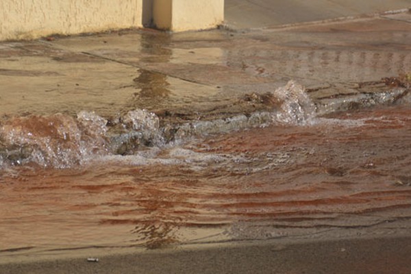 Vazamento intenso de água provoca estufamento do solo e danifica passeio em Patos de Minas