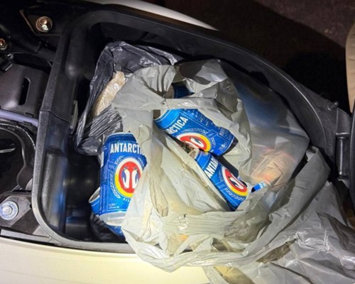 Condutora cai na Rua São Geraldo e acaba presa com baú da moto cheio de cervejas