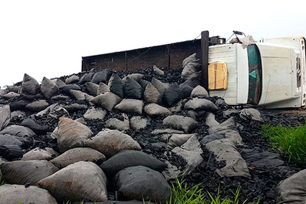 Caminhão tomba na MGC 354 em Patos de Minas e carga de carvão fica espalhada no local