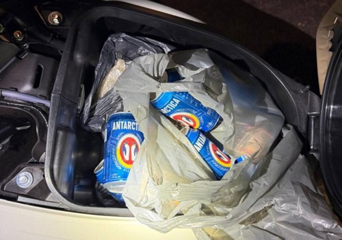 Condutora cai na Rua São Geraldo e acaba presa com baú da moto cheio de cervejas