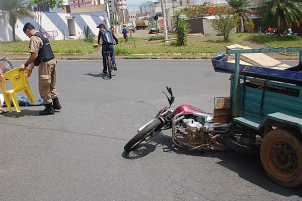 Motociclista tenta ultrapassagem e moto vai parar debaixo de carretinha no centro da cidade