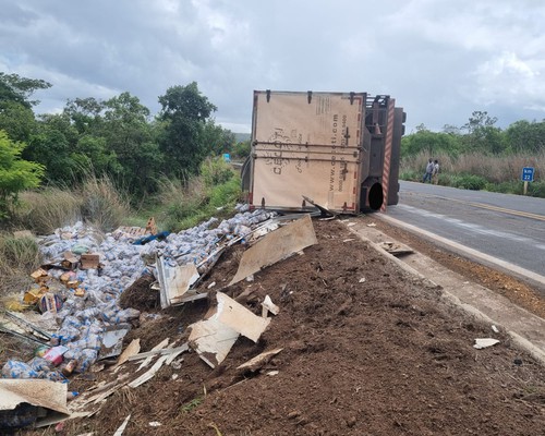 Caminhão baú com 11 toneladas de feijão tomba na MG 410 e parte da carga se espalha fora da pista