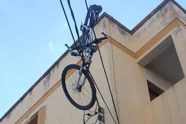 Briga entre irmãos acaba com bicicleta lançada do 2º andar na rede elétrica