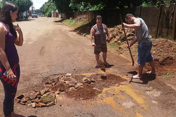 Após acidente com grávida de 7 meses, moradores usam terra para tapar buraco na rua São Geraldo