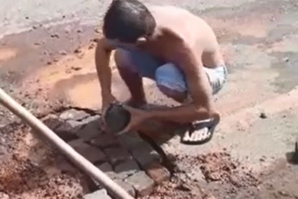 Para cobrar providências, moradores gravam vídeo tapando buracos de rua em Patos de Minas