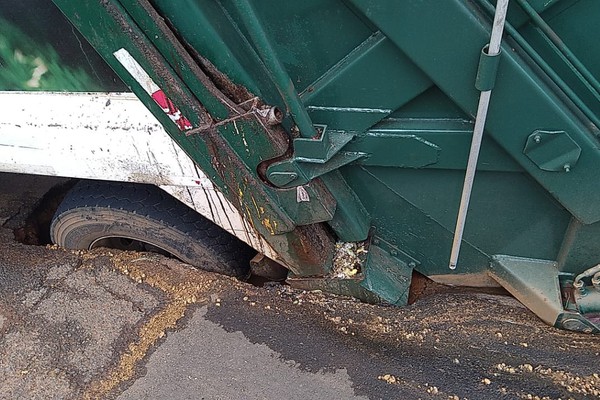 Caminhão de coleta de lixo afunda e fica atolado no asfalto no bairro Nossa Senhora das Graças
