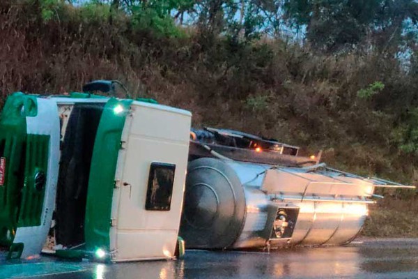 Caminhão carregado com leite aquaplana e deixa motorista ferido após tombamento na BR-352