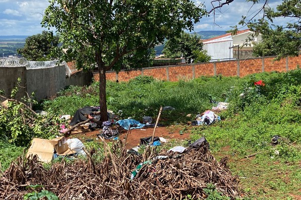 Mulher que vive em lote vago leva lixo para o local e deixa moradores preocupados, em Patos de Minas