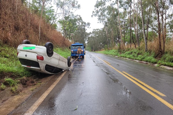 Carro derrapa durante forte chuva na MGC 354 e vai parar com as rodas para o alto