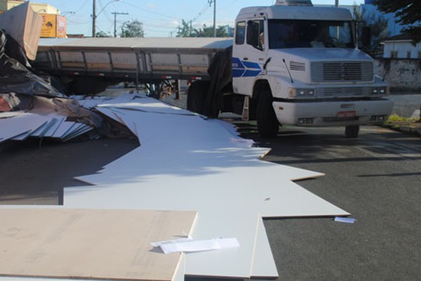 Carreta espalha placas de móveis planejados pelo asfalto ao tentar conversão em Patos de Minas