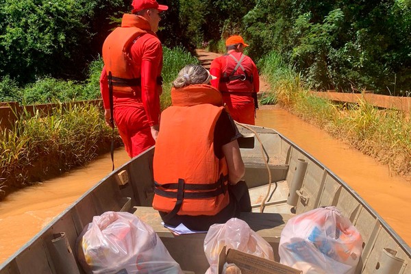 Bombeiros e Secretaria de Desenvolvimento Social usam embarcação para levar doações para famílias isoladas pela enchente