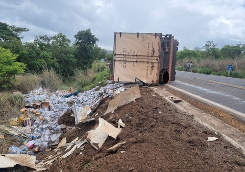 Caminhão baú com 11 toneladas de feijão tomba na MG 410 e parte da carga se espalha fora da pista