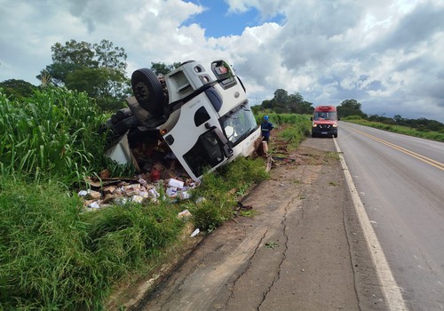 Motorista sai ileso após caminhão carregado com paçoca sair da pista e capotar na BR365