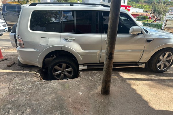 Calçada se abre e veículo fica preso em buraco de obra recente da Copasa em Patos de Minas
